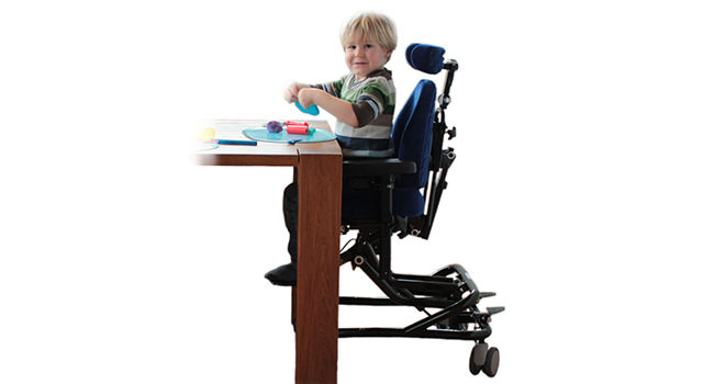 Kind sitzt auf EVI-Therapiestuhl an einem Tisch